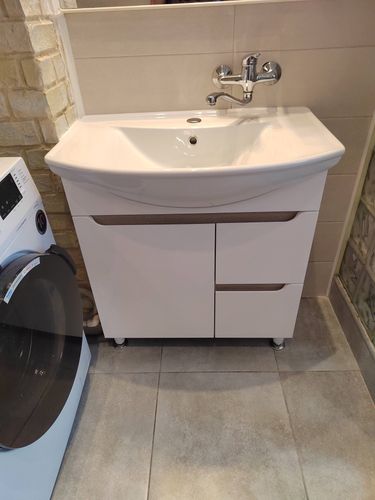 Установлена раковина с тумбой, подключен смеситель и слив, проверена герметичность соединений, произведена регулировка высоты ножек, обеспечена устойчивость конструкции.