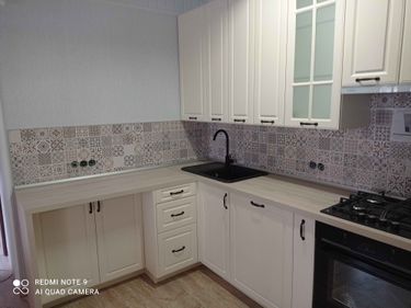 Установлены шкафы, закреплена столешница, вмонтирована мойка, подключена плита, смонтирован фартук. Все элементы выровнены, двери и ящики отрегулированы, завершена сборка.