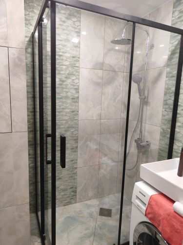 Установлена конструкция с прозрачными стенками и дверцами, закреплена на плитке. Смонтирован душевой комплект с лейкой и смесителем. Обеспечена герметичность соединений и стыков.