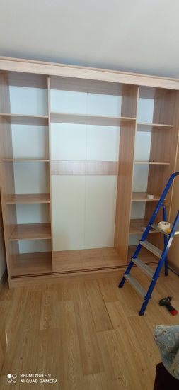 Собран шкаф с полками, закреплены детали, установлены боковые панели. Работа завершена, все элементы на местах, конструкция устойчива.