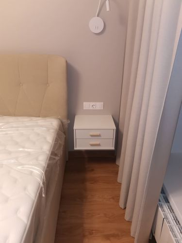 Собран прикроватный шкафчик с двумя выдвижными ящиками. Установлены ручки, закреплены направляющие, проверена устойчивость и плавность работы механизмов.