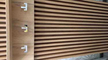 Деревянная панель с тремя аккуратно закрепленными крючками, готовыми для использования. Эстетичное и функциональное решение для хранения одежды.