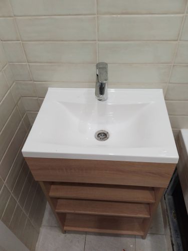 Установлено новое оборудование: раковина с тумбой, подключены водопроводные коммуникации, закреплен смеситель, проверена герметичность соединений, выполнена отделка плиткой.