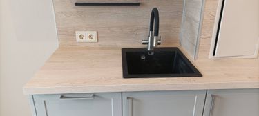 Установлена новая раковина с современным смесителем на кухонной столешнице. Подключены коммуникации, обеспечена герметичность соединений и функциональность системы.