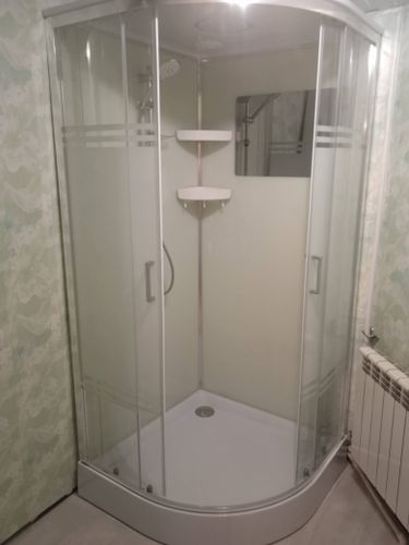 Установлена современная душевая конструкция с гидромассажем, подключены водопроводные коммуникации, герметично закреплены стеклянные панели, смонтированы полки и зеркало.