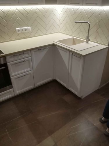 Установлена новая поверхность из искусственного камня, выполнены вырезы для мойки и смесителя, обеспечена точная подгонка и герметизация швов, завершена интеграция с кухонными элементами.