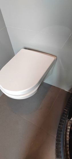 Закреплена конструкция для подвесного унитаза, подключены водопровод и канализация, установлена чаша, проверена герметичность соединений, выполнена облицовка стен плиткой.