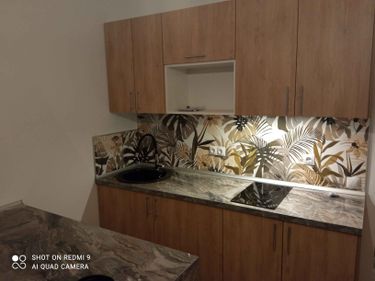 Установлена новая кухонная поверхность с точными вырезами под варочную панель и мойку. Материал подогнан по размерам, обеспечивая идеальное прилегание к стенам и мебели.