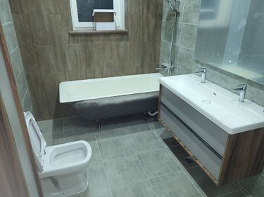 Завершена установка зеркала в ванной комнате. Оно аккуратно закреплено над раковиной, обеспечивая удобство использования и эстетичный вид интерьера.