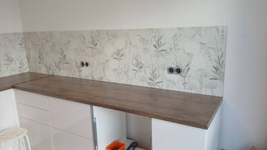 На кухне установлены новые розетки, проведена проводка, выполнено подключение к сети. Все элементы аккуратно вмонтированы в стену с цветочным узором, обеспечивая удобство и функциональность.