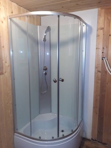 Установлена новая душевая кабина с прозрачными дверцами и современным смесителем. Стены облицованы панелями, подведены коммуникации, обеспечена герметичность и функциональность конструкции.