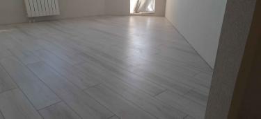 Выполнена укладка светлого ламината на ровное основание. Полы выглядят гладкими и аккуратными, создавая современный и стильный интерьер.