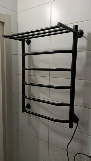 Установлен новый электрический прибор на стену в ванной комнате, подключен к сети, проверена работоспособность, обеспечена надежная фиксация и безопасность использования.