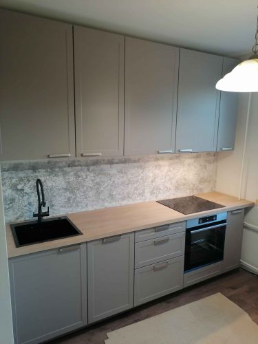 Установлены шкафы, закреплены фасады, смонтирована столешница, врезана мойка, подключена варочная панель, закреплены ручки, выполнены отделочные работы.