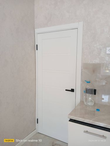 Установлена светлая деревянная дверь, закреплены петли, врезана ручка, отрегулировано полотно, выполнена отделка проема, обеспечена плавная работа конструкции.