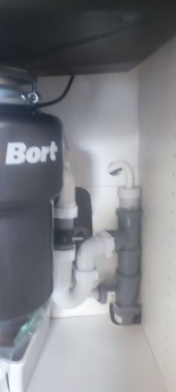 Установлены кухонные шкафы, закреплена столешница, подключена сантехника, смонтирована система водоотведения. Все элементы надежно зафиксированы, обеспечена функциональность.