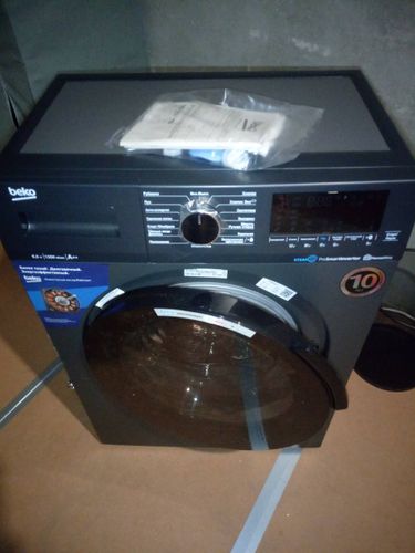 Изображена установленная стиральная машина: подключены шланги, выровнена по уровню, подключена к электросети, проверена на работоспособность, выполнено тестирование всех функций.