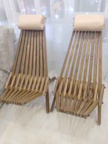 Собрано деревянное кресло: установлены ножки, закреплены планки, добавлена мягкая подушка для комфорта. Конструкция устойчива, все элементы надежно соединены, готово к использованию.