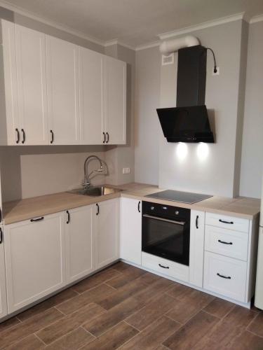 Установлены шкафы, смонтирована столешница, подключены варочная поверхность и вытяжка, вмонтирована раковина с краном, закреплены ручки, выровнены фасады, подключены розетки.