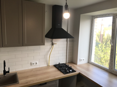 Установлены шкафы, смонтирована столешница, подключена варочная панель и вытяжка. Установлена мойка и смеситель, проведены коммуникации. Завершена облицовка фартука плиткой.