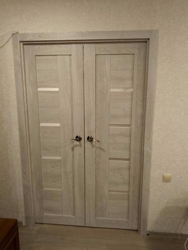 Установлены двустворчатые двери: закреплены петли, врезаны замки, отрегулированы створки, установлены ручки, оформлены наличники, произведена финальная подгонка и проверка функциональности.