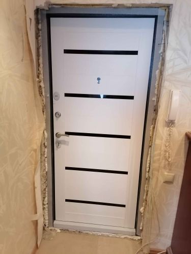 Установлена новая металлическая дверь, закреплена в проеме, зазоры заполнены монтажной пеной для герметичности, обеспечена надежная защита и безопасность помещения.