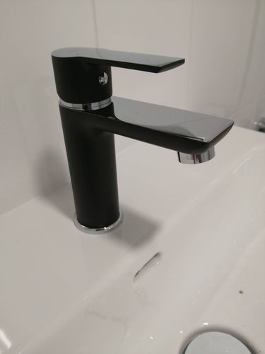 Установлен новый черный кран на раковину в ванной комнате. Завершены работы по подключению водопровода, проверена герметичность соединений, обеспечена функциональность и эстетика.