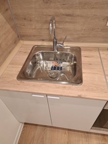 Установлен новый кран на кухонную мойку, подключены водопроводные трубы, проверена герметичность соединений, обеспечена функциональность и эстетичность.