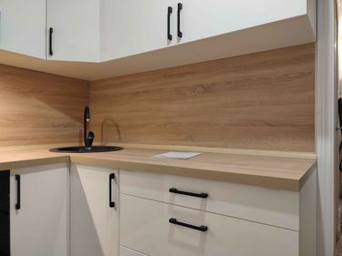 Установлены шкафы, закреплены фасады, смонтированы полки. Смеситель подключен, столешница уложена. Ручки прикреплены, фартук зафиксирован. Все элементы собраны и выровнены.