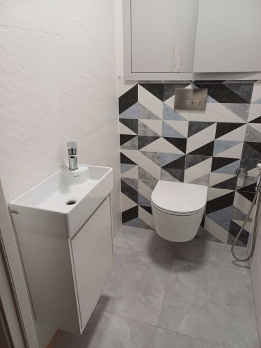 Изображение демонстрирует завершённую установку раковины в ванной комнате. Раковина закреплена, подключены трубы, смеситель установлен, обеспечена герметичность соединений.