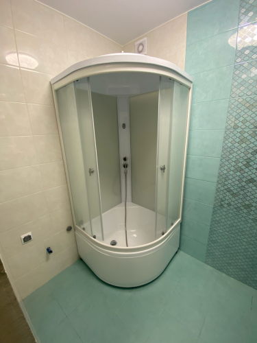 Установлена современная душевая кабина, заменены старые коммуникации, обновлено покрытие стен и пола, обеспечена герметизация, подключено водоснабжение и слив, проверена функциональность.