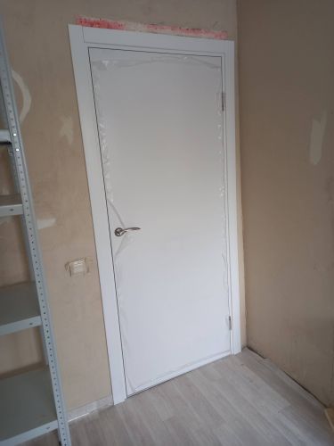 Установлена новая деревянная дверь, закреплены петли, врезана ручка, выровнена коробка, произведена отделка откосов, проверена функциональность, завершены отделочные работы.