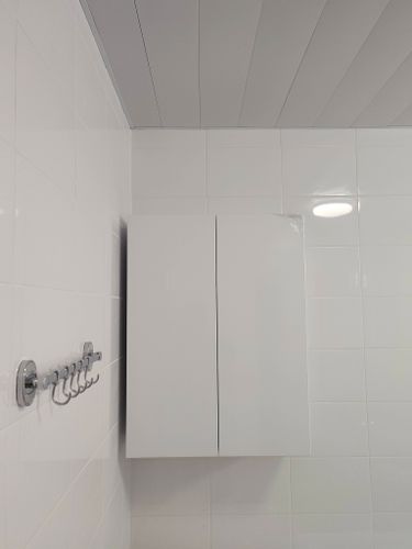 На стене ванной комнаты закреплён шкаф с зеркальными дверцами. Установлены крепления, обеспечивающие надёжность и устойчивость конструкции. Всё выполнено аккуратно и ровно.