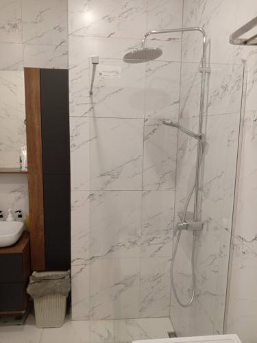 Ванная комната обновлена: установлена стеклянная перегородка для душа, облицовка стен выполнена плиткой с мраморным узором. Пространство стало современным и функциональным.