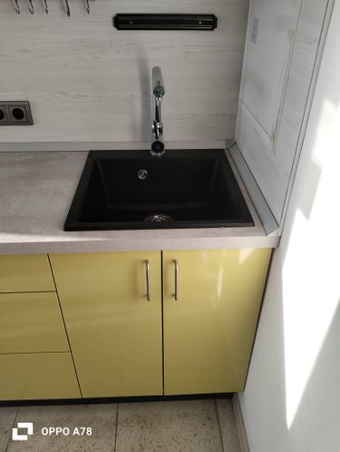 Под раковиной закреплено устройство для переработки отходов, подключено к водопроводу и электричеству, проверена герметичность соединений, обеспечена надежная работа системы.