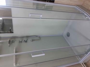 Установлены стеклянные панели, закреплены дверцы, подключен смеситель, проверен слив, герметизированы швы, смонтирован поддон, подключены коммуникации, установлены полки.