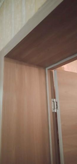 Выполнена установка декоративных панелей вокруг дверного проема. Аккуратно закреплены элементы, обеспечивая ровное прилегание и гармоничный внешний вид. Завершено оформление входной зоны.