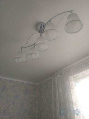 Установлено осветительное устройство на потолок, подключены провода, закреплены крепежи, проверена работа. Люстра висит ровно, светильники направлены вниз, обеспечивая равномерное освещение.