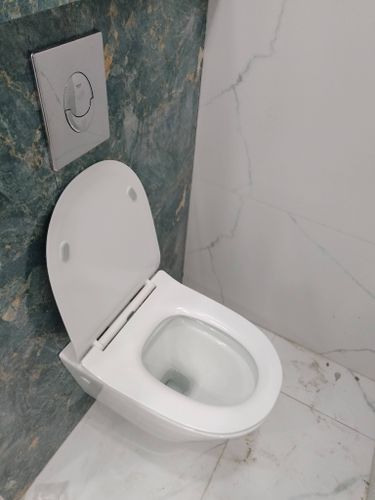 Установлен подвесной унитаз: закреплена чаша, подключена система слива, смонтирована инсталляция, проверена герметичность соединений, выполнена облицовка плиткой.