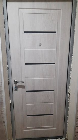 Выполнена установка дверной конструкции из пластика: закреплён короб, навешено полотно, вставлены ручки, отрегулированы петли, зазоры заполнены монтажной пеной для герметичности.