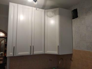 Установлены навесные шкафы, закреплены дверцы, прикреплены ручки. Проведена регулировка фасадов, проверена устойчивость конструкции. Подключена раковина, завершена отделка стен.