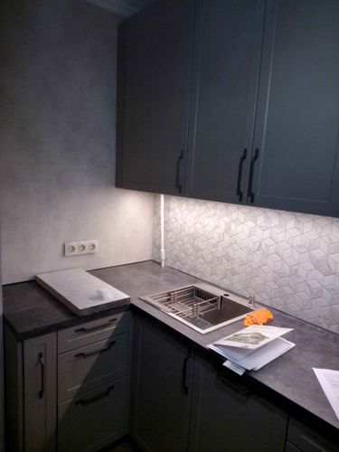 Установлены шкафы, закреплены ручки, смонтирована столешница, встроена мойка, подключены коммуникации, уложен фартук, завершена отделка. Все элементы гармонично сочетаются.