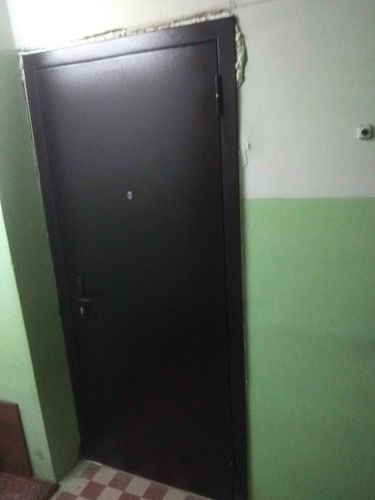 Проведены работы по уменьшению проема: установлена новая дверь, зазоры заделаны монтажной пеной, поверхность выровнена, окрашена в тон стены, обеспечена надежная изоляция и плотное прилегание.