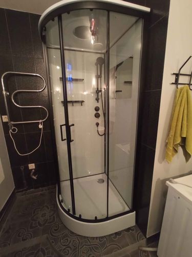 Установлена современная душевая кабина с прозрачными дверцами, заменены коммуникации, обновлены стены и пол, добавлены полки для удобства, обеспечена герметичность и функциональность.