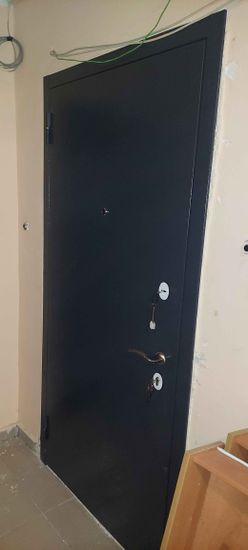 Установлено новое дверное полотно, закреплены петли, врезан замок, отрегулированы ручки. Проведена герметизация стыков, проверена функциональность конструкции. Завершены отделочные работы.