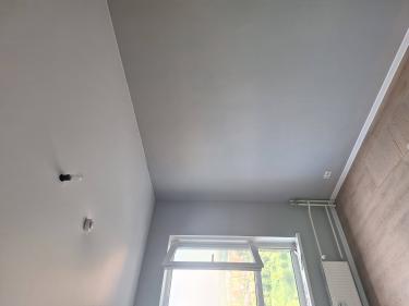 Комната преобразилась: поверхности окрасили в светло-серый оттенок, создавая свежий и современный вид. Аккуратные линии и ровное покрытие подчеркивают качество выполненной работы.