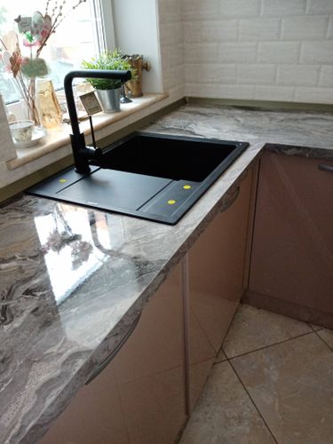 Установлена новая столешница из ДСП, аккуратно подогнана к стенам, вырезано отверстие для мойки, закреплены все элементы, обеспечена герметизация стыков, поверхность тщательно выровнена.