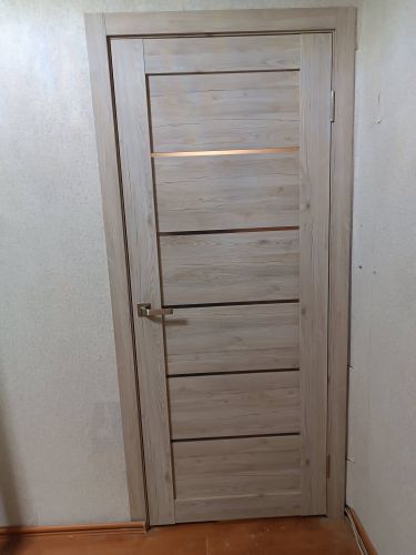 Установлен запорный механизм на деревянную створку. Выполнено сверление, вырезание отверстия, закрепление ручки, проверка функционирования. Работа завершена аккуратно, без повреждений.