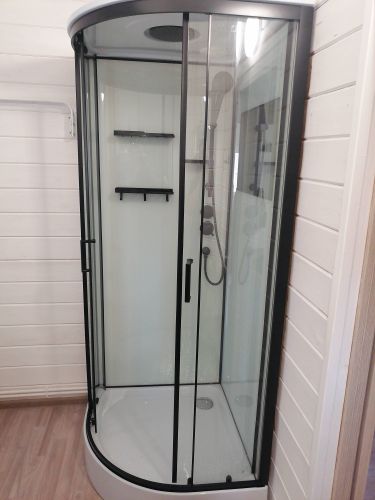 Установлена современная душевая кабина с прозрачными стеклянными дверями и черными рамами. Обновлены коммуникации, добавлены полки для удобства. Пол выложен новым покрытием.