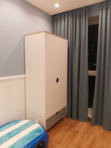 Собран шкаф: установлены панели, прикреплены дверцы, закреплены полки, выдвижные ящики на месте, все элементы надежно соединены, конструкция устойчива, готова к использованию.